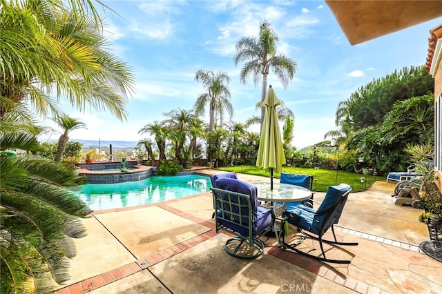 view of pool featuring an in ground hot tub, a yard, and a patio