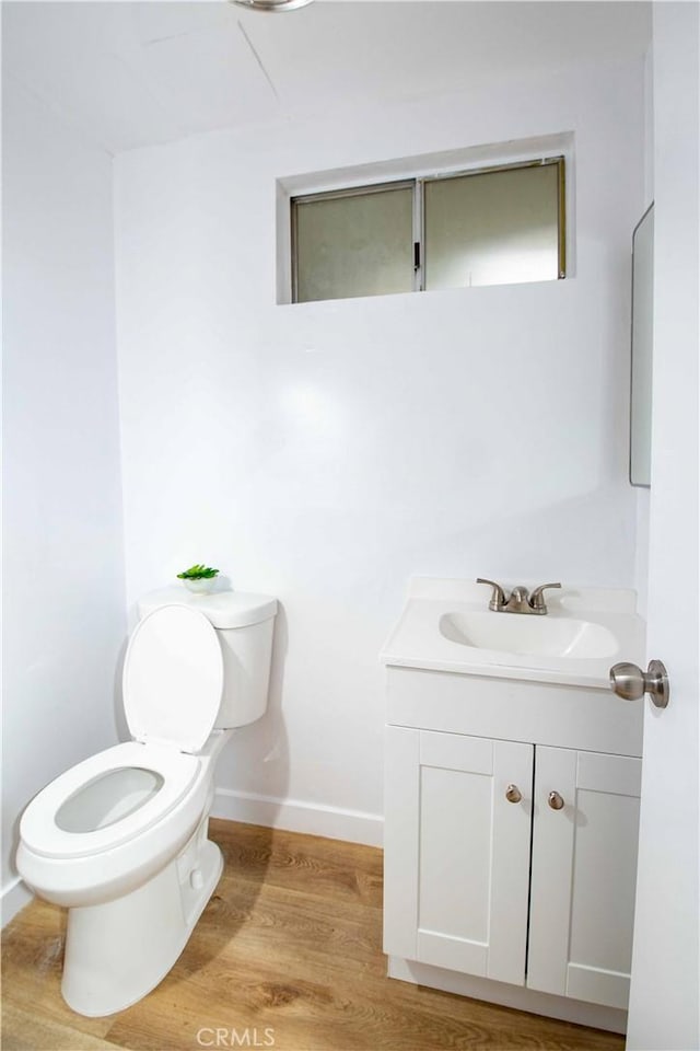 bathroom featuring vanity, hardwood / wood-style flooring, and toilet