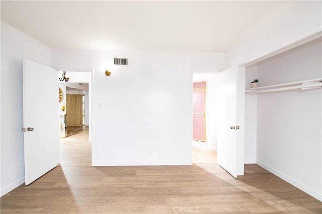 unfurnished bedroom with a closet and light wood-type flooring