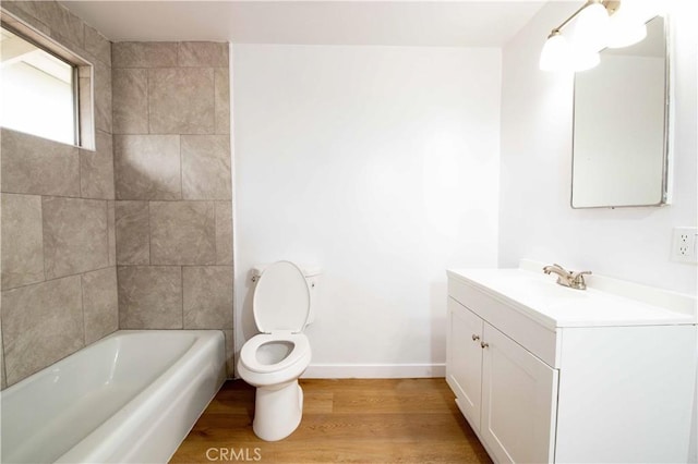 full bathroom featuring vanity, toilet, wood-type flooring, and tiled shower / bath combo