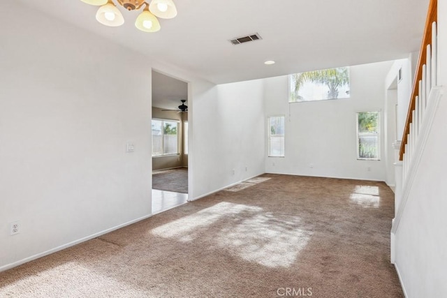 spare room with an inviting chandelier and carpet