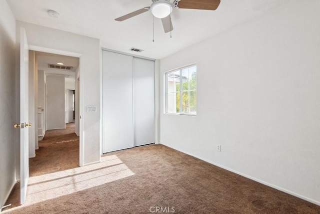 unfurnished bedroom featuring light colored carpet, ceiling fan, and a closet