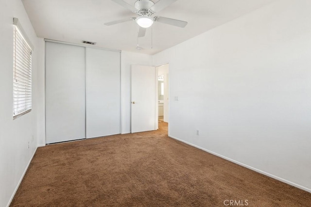 unfurnished bedroom with carpet, ceiling fan, and a closet