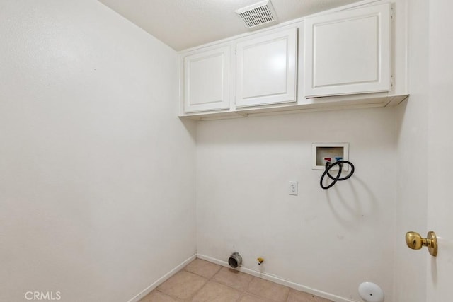 laundry area with hookup for a gas dryer, hookup for a washing machine, light tile patterned floors, and cabinets