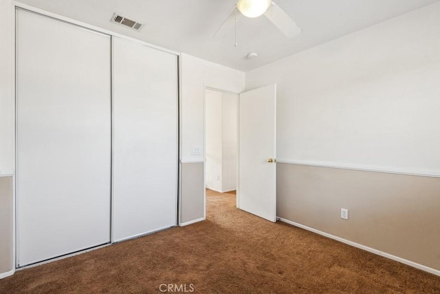 unfurnished bedroom featuring light colored carpet, ceiling fan, and a closet