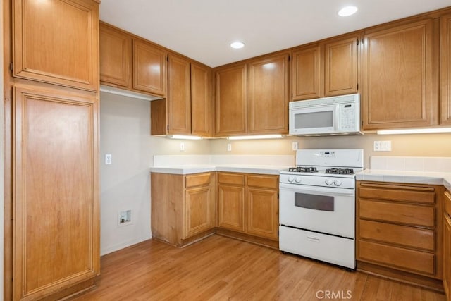 kitchen featuring white appliances and light hardwood / wood-style flooring