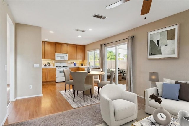 kitchen featuring white appliances, light hardwood / wood-style flooring, and ceiling fan