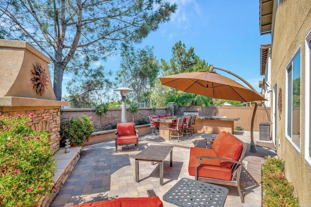 view of patio / terrace featuring an outdoor bar and an outdoor stone fireplace