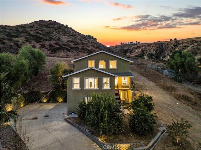 property exterior at dusk with a mountain view