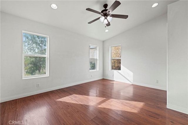 spare room featuring ceiling fan, dark wood-type flooring, and vaulted ceiling