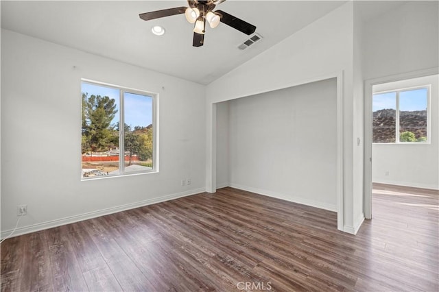 interior space featuring ceiling fan, vaulted ceiling, and dark wood-type flooring