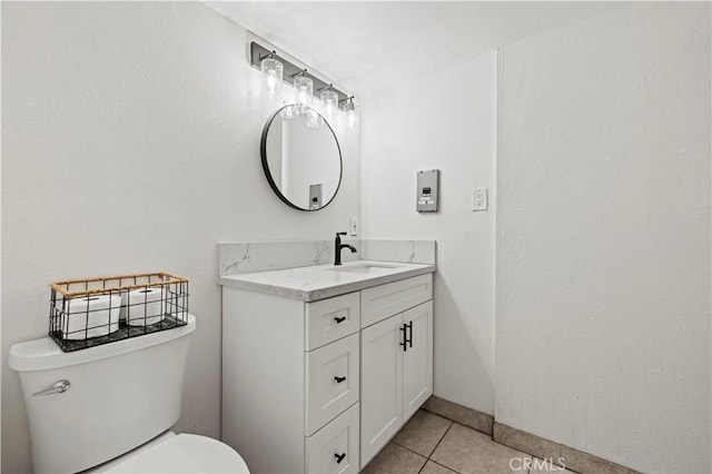 bathroom featuring tile patterned flooring, vanity, and toilet