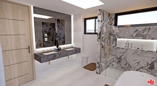 bathroom featuring sink, a washtub, and tile walls