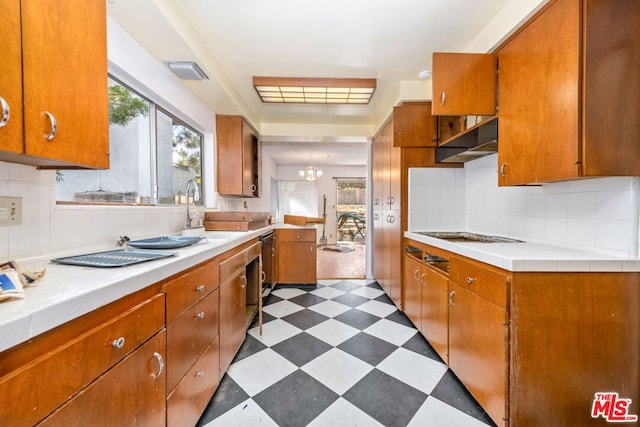 kitchen featuring sink, an inviting chandelier, and decorative backsplash