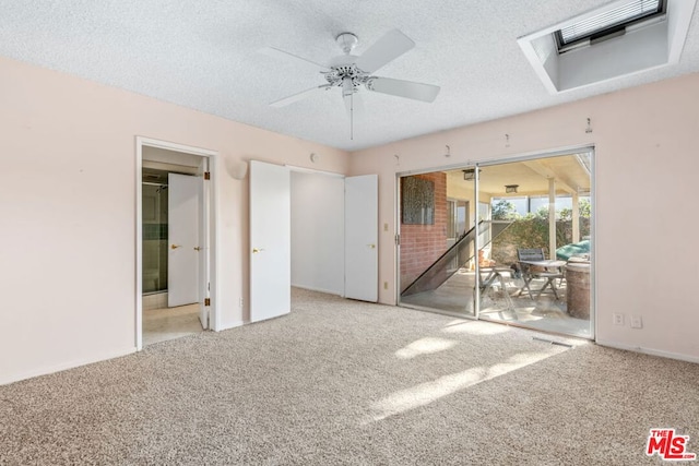 unfurnished bedroom featuring ceiling fan, light carpet, and a textured ceiling