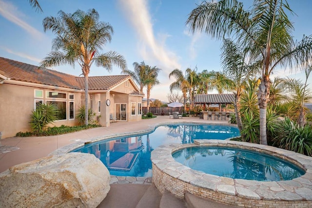 view of swimming pool featuring an outdoor bar, a patio area, and an in ground hot tub