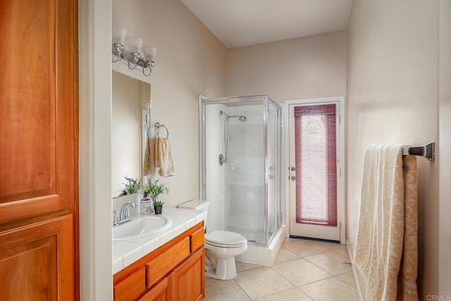 bathroom with toilet, vanity, tile patterned flooring, and a shower with door