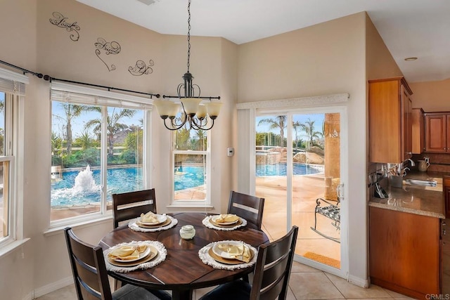 dining area featuring light tile patterned floors, a notable chandelier, and sink