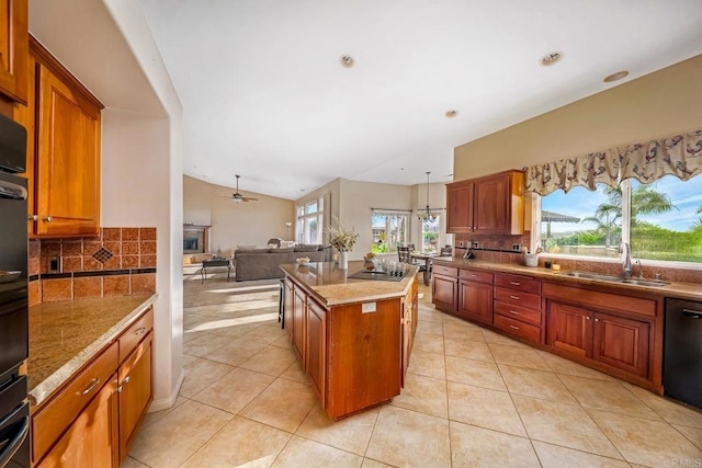 kitchen featuring black appliances, a kitchen island, decorative light fixtures, sink, and backsplash