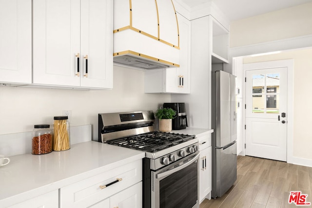 kitchen featuring white cabinets, light wood-type flooring, and appliances with stainless steel finishes