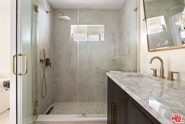 bathroom with vanity and a shower with door