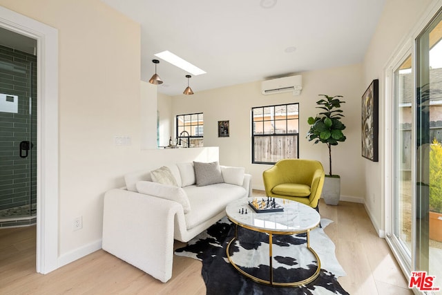 living room with light hardwood / wood-style flooring, a wall unit AC, and a skylight