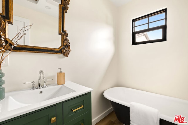 bathroom featuring vanity, hardwood / wood-style flooring, and a bathtub