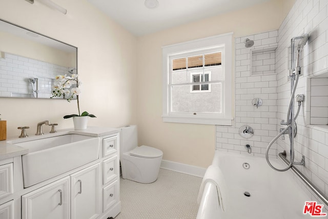 full bathroom featuring tile patterned floors, vanity, toilet, and tiled shower / bath combo