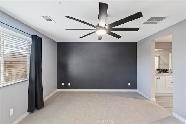 carpeted spare room with ceiling fan