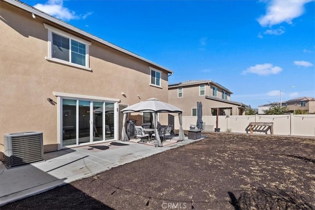 rear view of property with a gazebo, a patio area, and central air condition unit