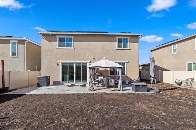 rear view of property with cooling unit and a patio area