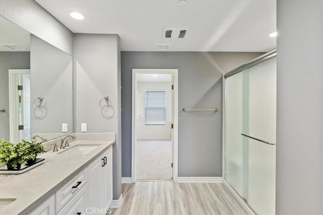 bathroom featuring vanity, hardwood / wood-style flooring, and a shower with shower door