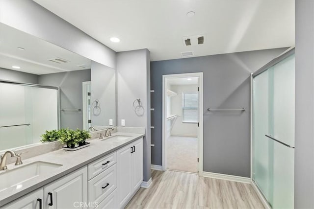 bathroom featuring hardwood / wood-style floors, vanity, and an enclosed shower