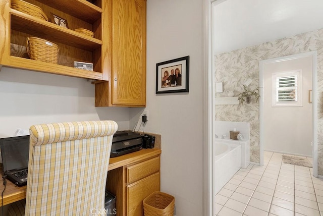 home office with built in desk and light tile patterned flooring