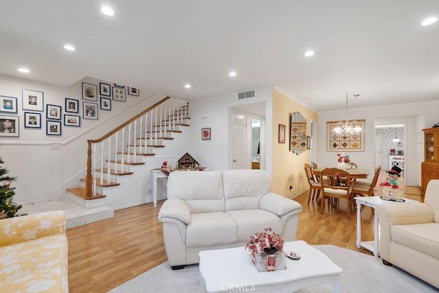 living room with recessed lighting, visible vents, light wood-style flooring, and stairs