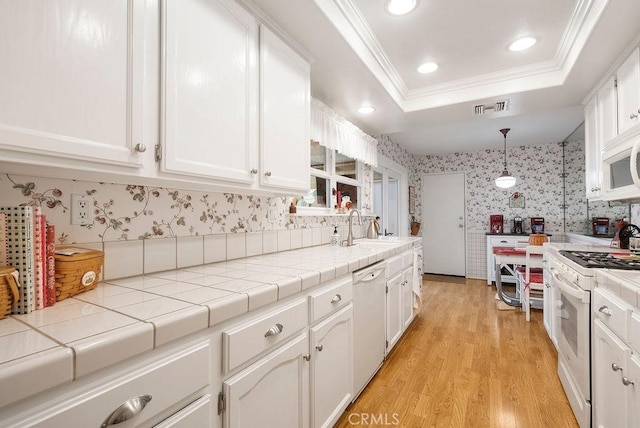 kitchen featuring white cabinetry, white appliances, a raised ceiling, and wallpapered walls