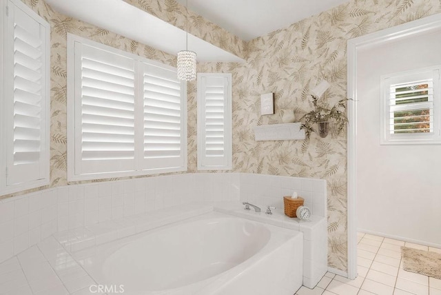 bathroom with baseboards, tile patterned flooring, a bath, and wallpapered walls