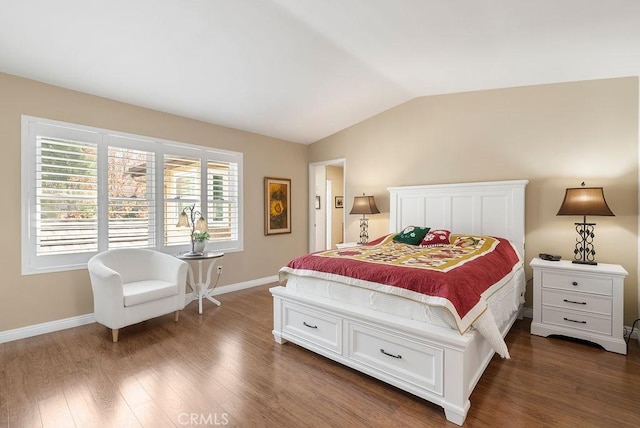 bedroom featuring lofted ceiling, dark wood-style floors, and baseboards