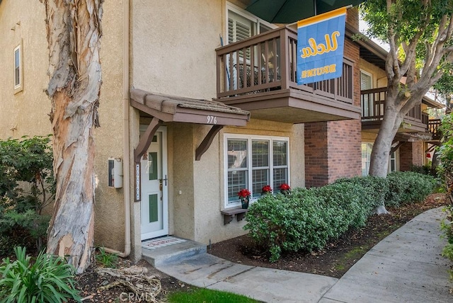 property entrance featuring brick siding and stucco siding