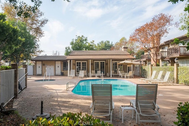 community pool featuring a patio, french doors, and fence