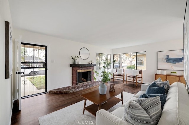 living room with a fireplace, dark hardwood / wood-style flooring, and a healthy amount of sunlight