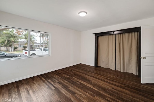 unfurnished bedroom with dark wood-type flooring