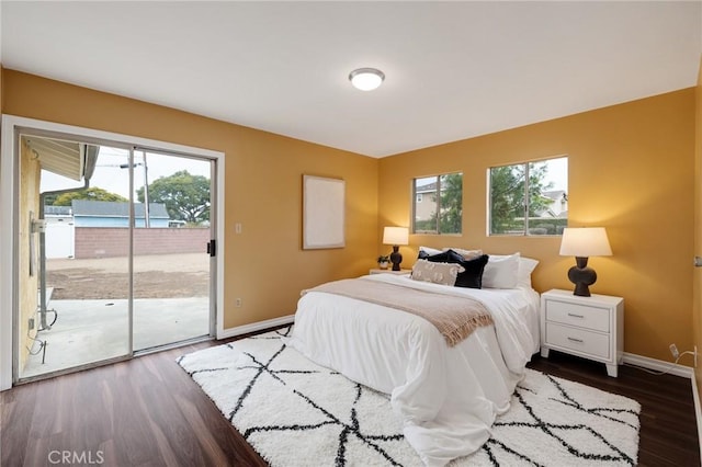 bedroom featuring access to exterior, dark hardwood / wood-style floors, and multiple windows