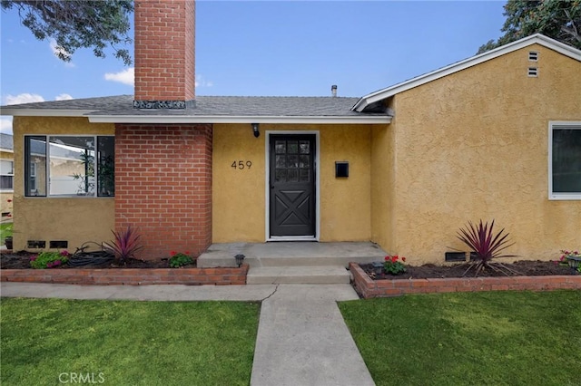 entrance to property featuring a yard