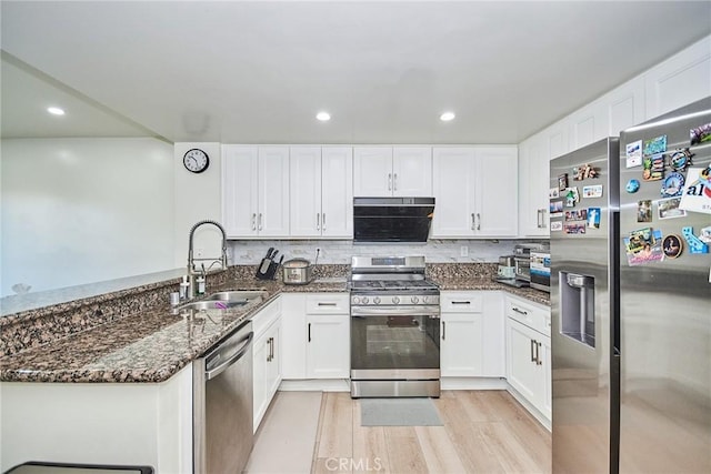 kitchen featuring appliances with stainless steel finishes, light hardwood / wood-style floors, white cabinetry, and sink