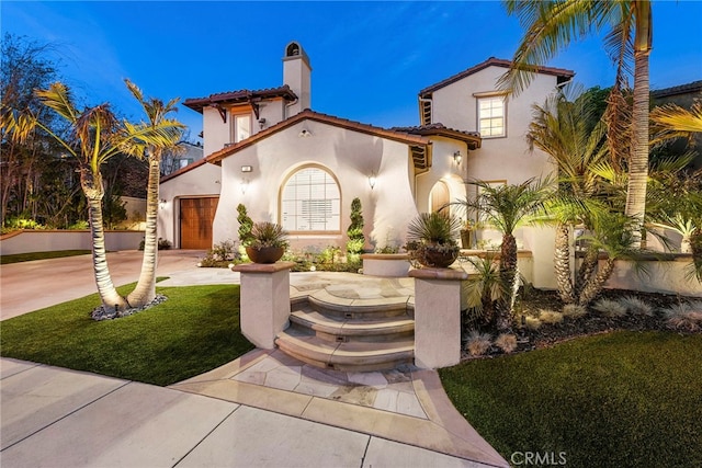 mediterranean / spanish house with a garage and a front yard