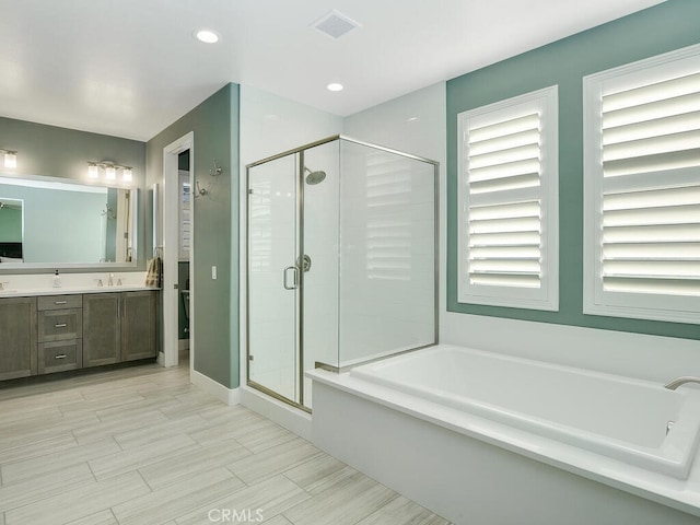 bathroom with vanity and independent shower and bath