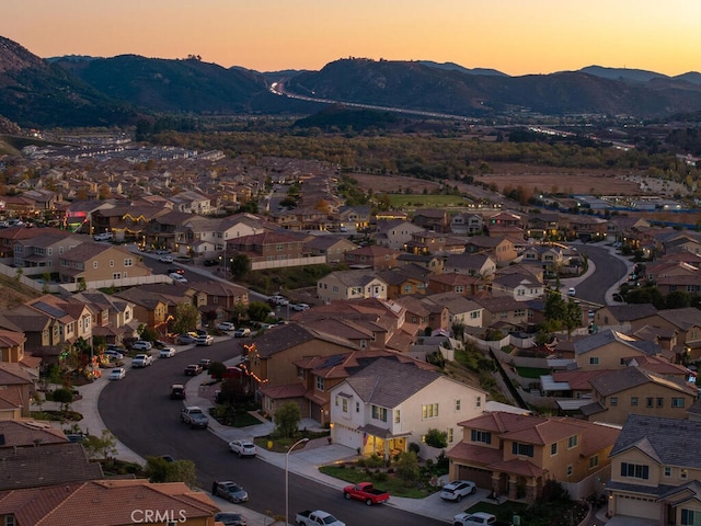 aerial view at dusk featuring a mountain view