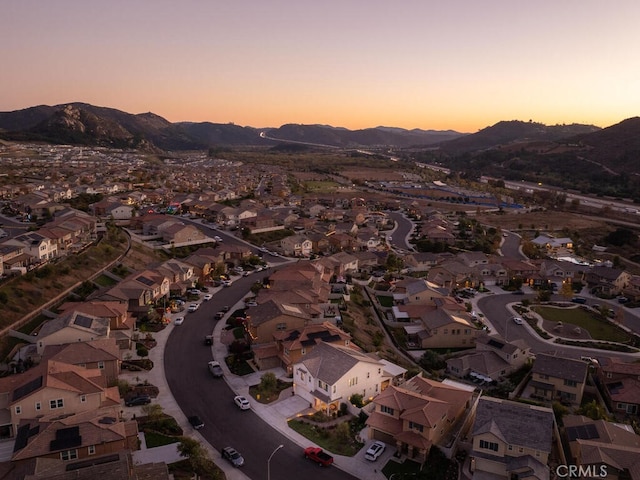 aerial view at dusk featuring a mountain view