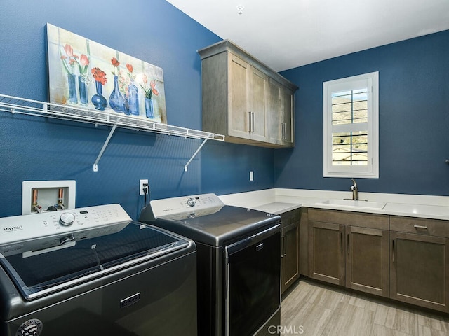 laundry room with separate washer and dryer, sink, cabinets, and light hardwood / wood-style floors